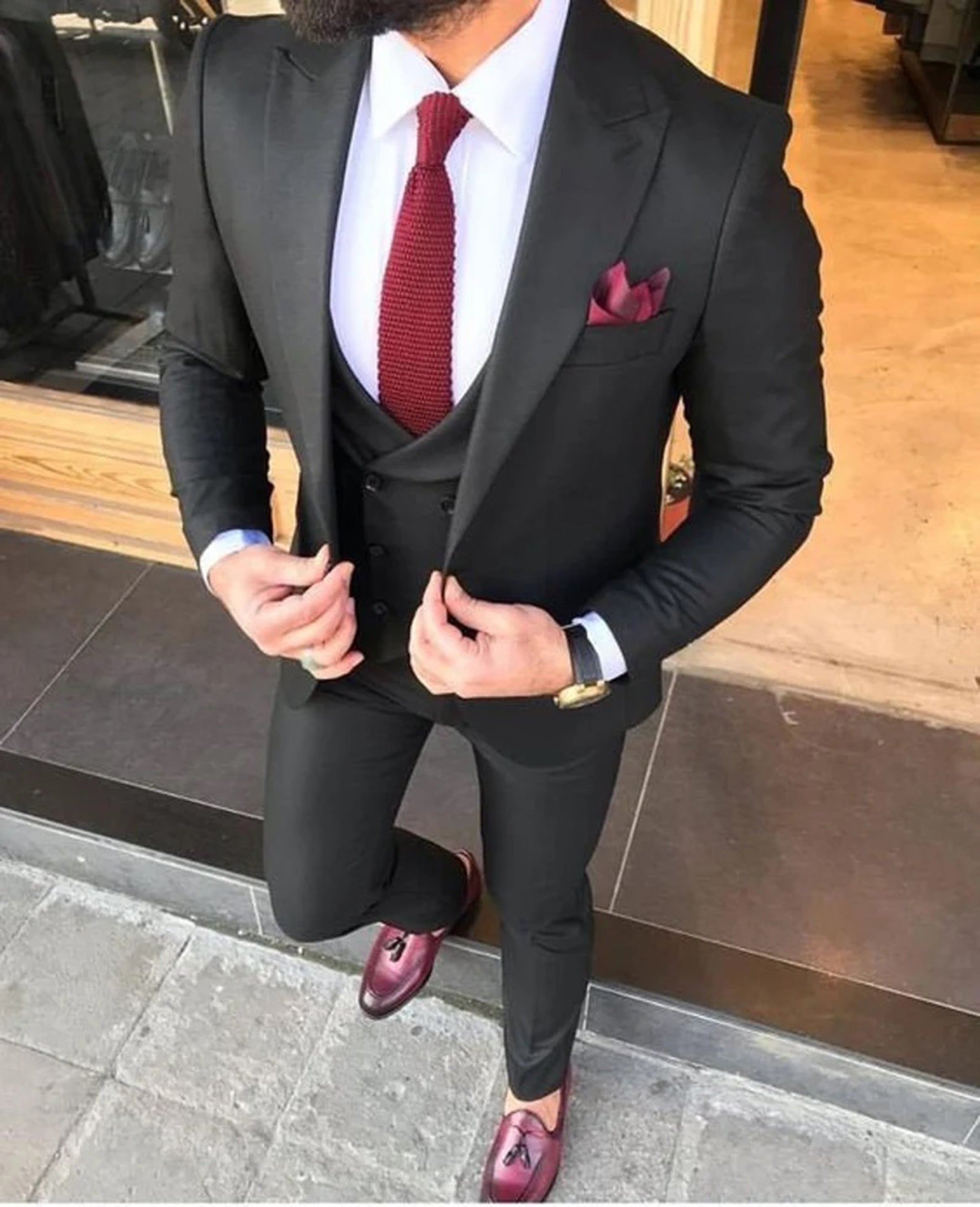 Men's elegant black three-piece suit with sleek jacket, tailored trousers, and waistcoat, ideal for business and formal occasions.