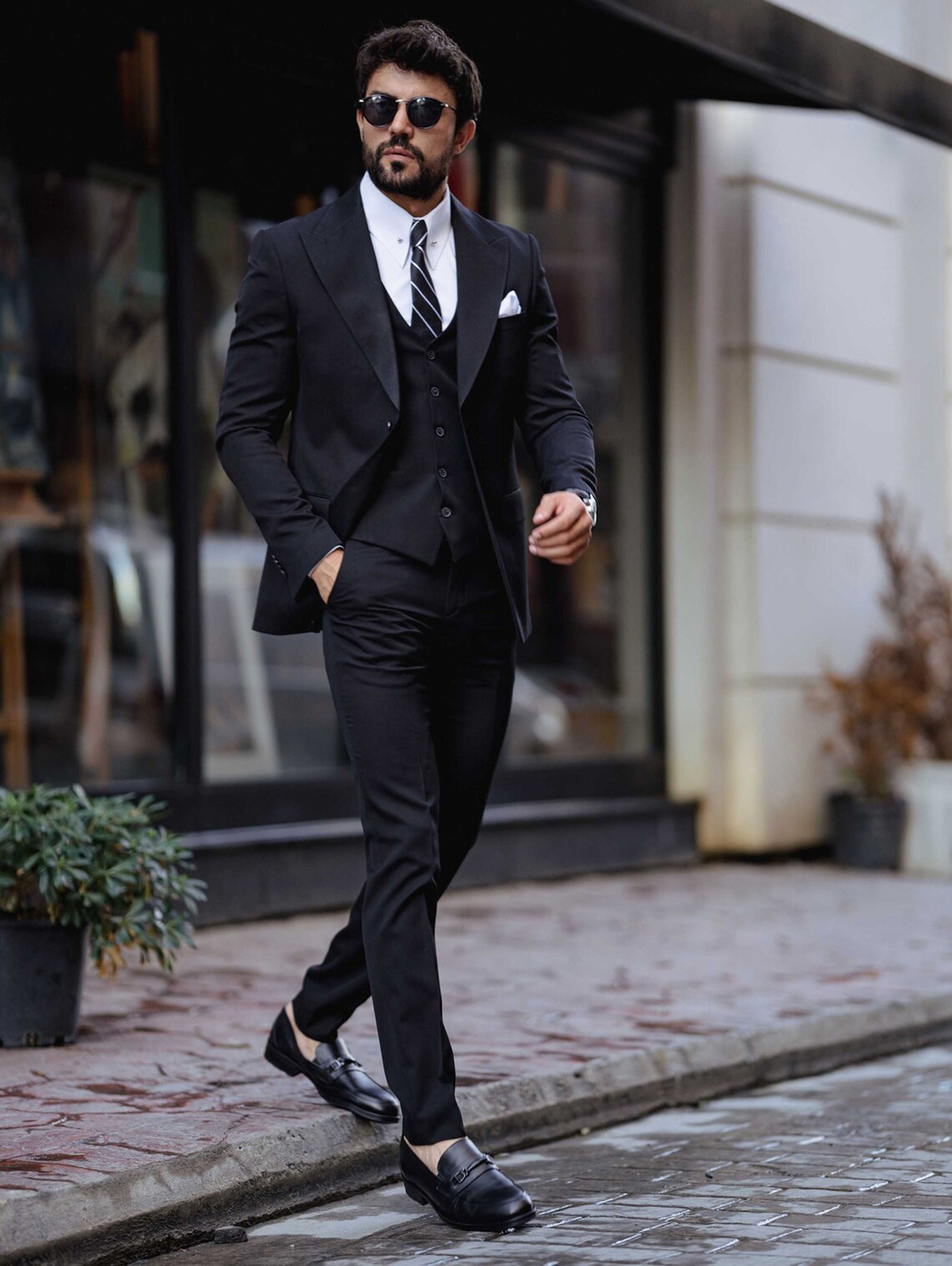 Men's elegant black slim-fit three-piece suit for formal events.